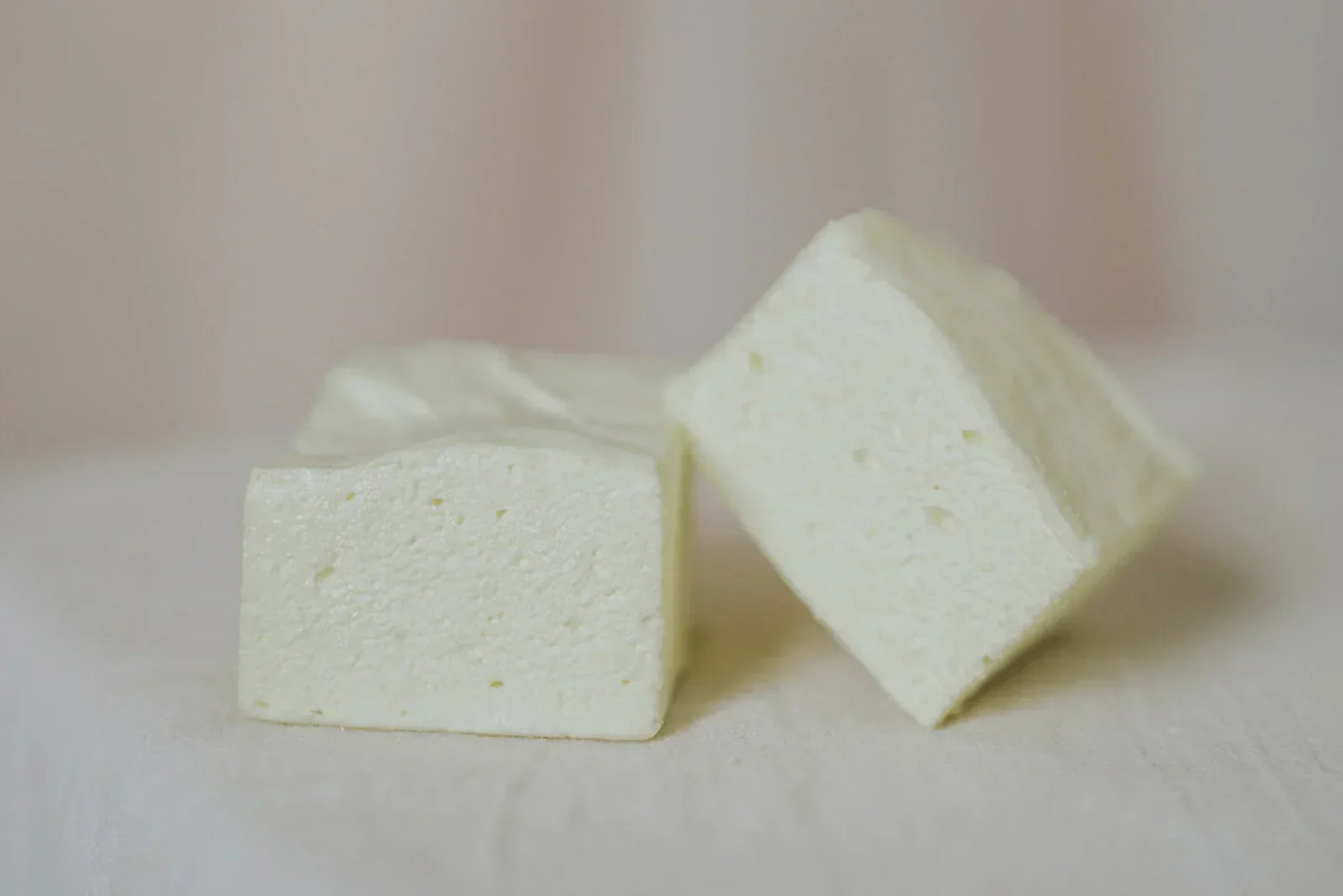 Lemon flavoured marshmallows on a plain background