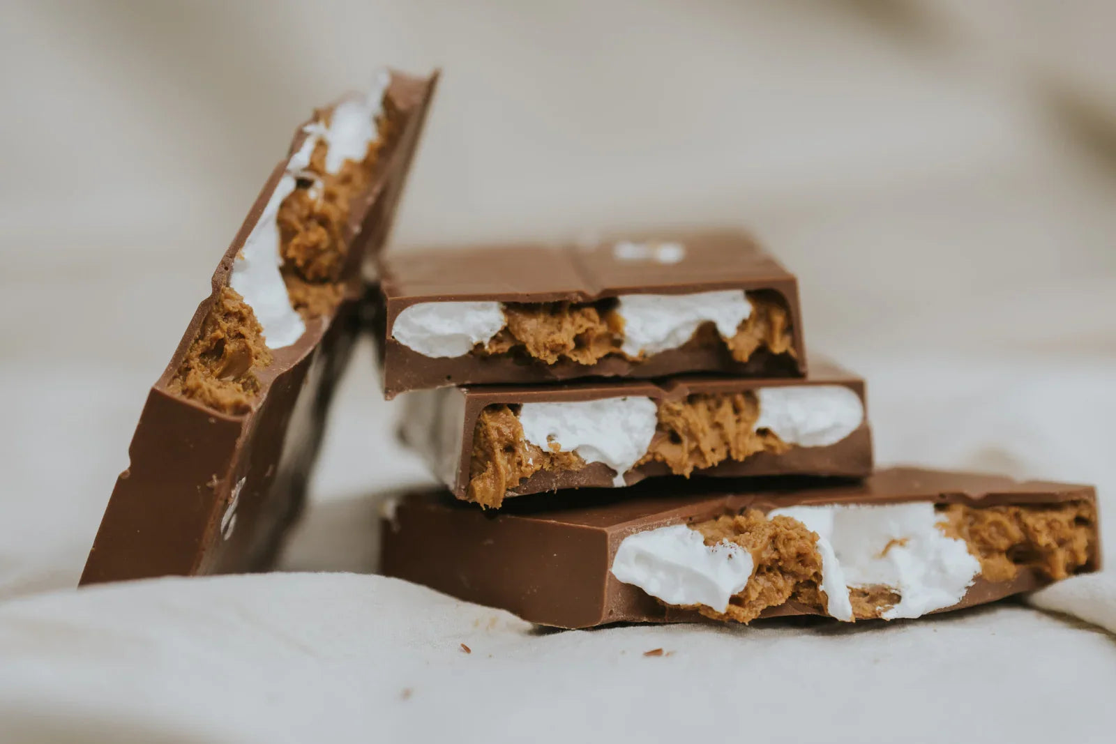 Chocolate bars with lotus biscoff and marshmallow fluff filling on a soft surface