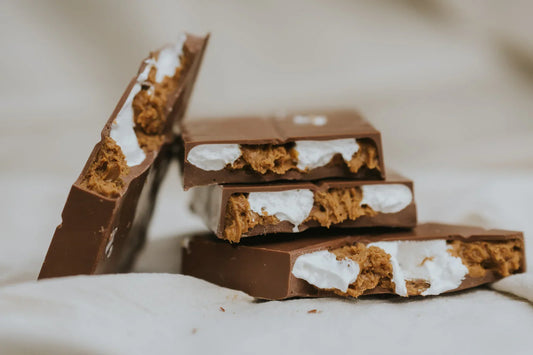 Chocolate bars with lotus biscoff and marshmallow fluff filling on a soft surface