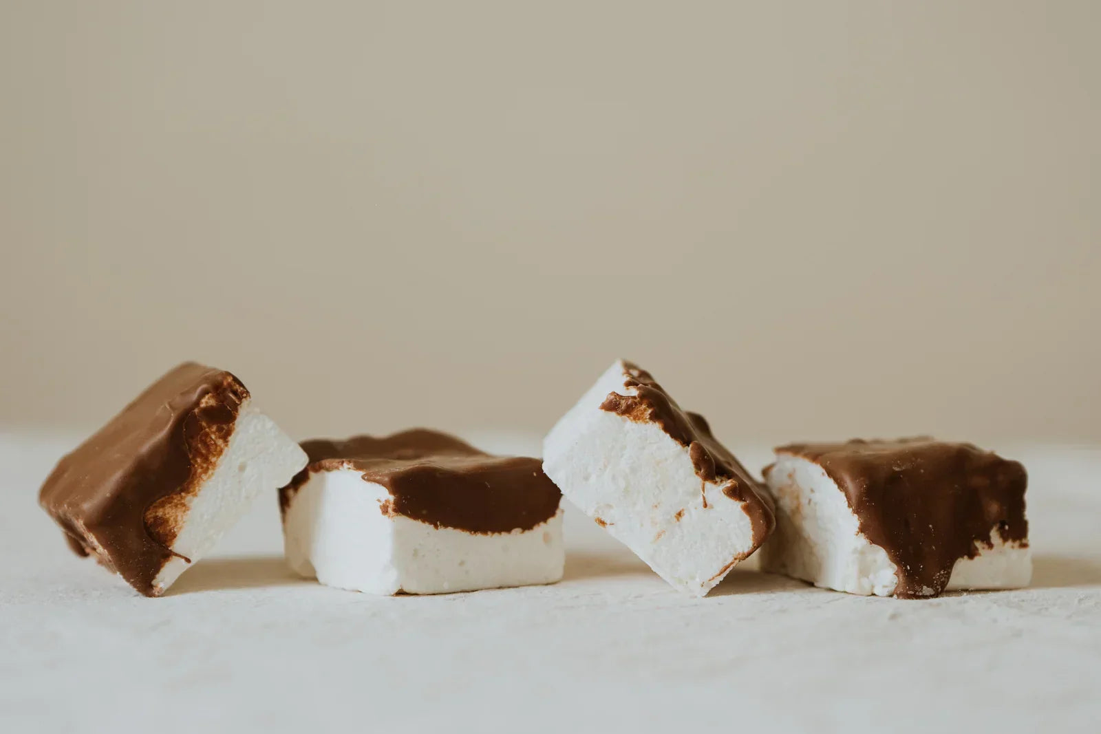 Chocolate-dipped coffee marshmallows on a light background