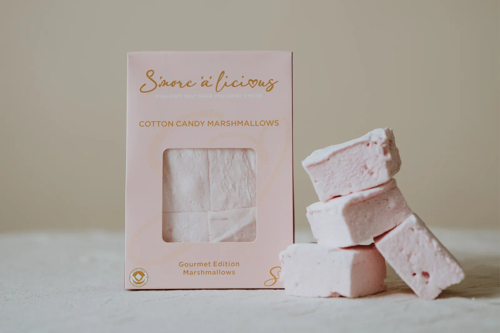 Pink cotton candy marshmallows with packaging on a light background